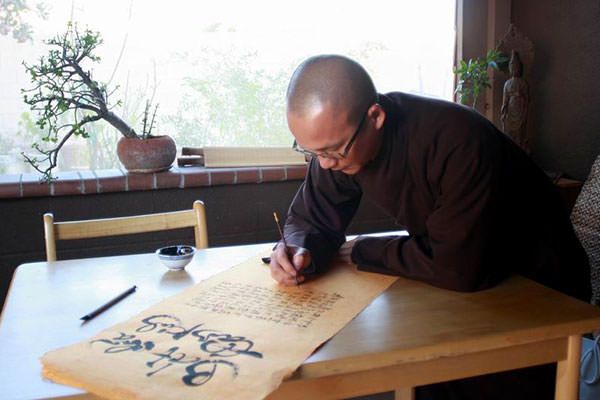 Chat Nguyen paints his Buddhist calligraphy at the temple
