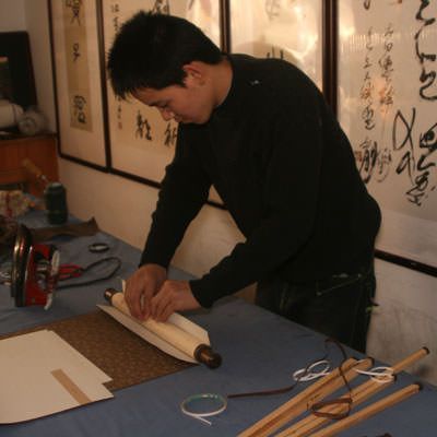 Adhesive is added to the roller and it is placed in the body of the wall scroll.